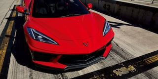 A Woman Lifted up the Front Hood of a 2025 Red Chevy Corvette Stingray