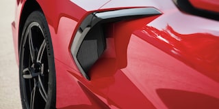 A Man with a Shopping Bag Walking Away from the Rear of a 2025 Red Chevy Corvette Stingray